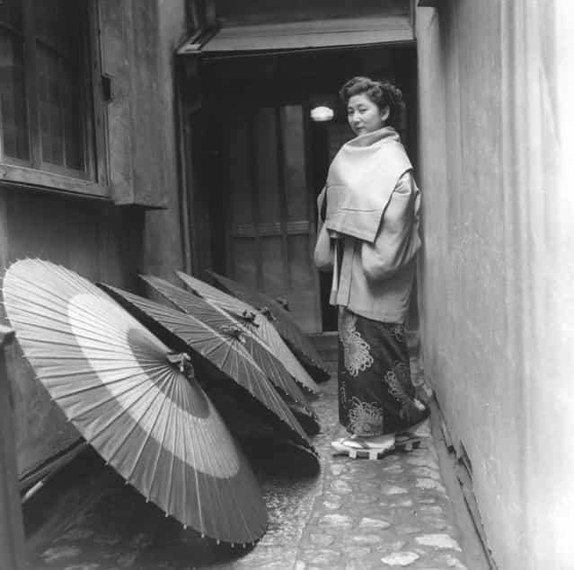 A geisha going home and passing a line of drying umbrellas in the alleyway, circa 1955. (Photo by Three Lions)