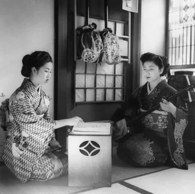 Two Geisha Girls, professional Japanese entertainers, practising their art; one is playing a samisen, a traditional Japanese stringed instrument, circa 1950. (Photo by Three Lions)