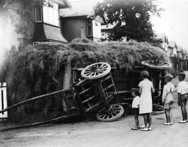 A group of children gather to look at an overturned hay cart in Cardiff. 3rd September 1936. (Photo by Richards/Fox Photos)