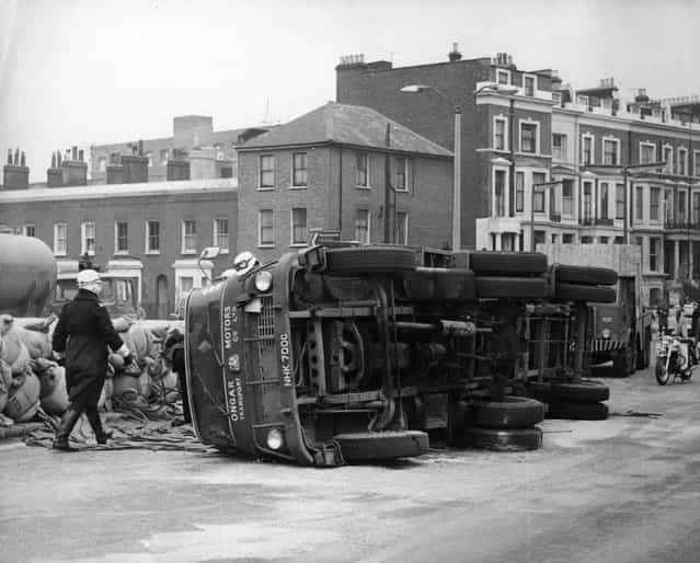 An articulated lorry blocks the main road out of London, the West Cromwell road, after it overturned due to an unstable load, circa 1965. (Photo by Keystone)