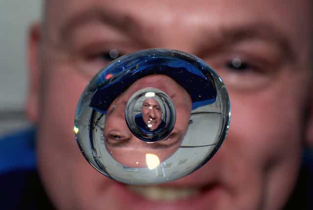 Astronaut Andre Kuipers watches a bubble in a drop of water as he enjoys his last days of weightlessness aboard the International Space Station, on June 24, 2012. (Photo by AP Photo/NASA, Andre Kuipers)