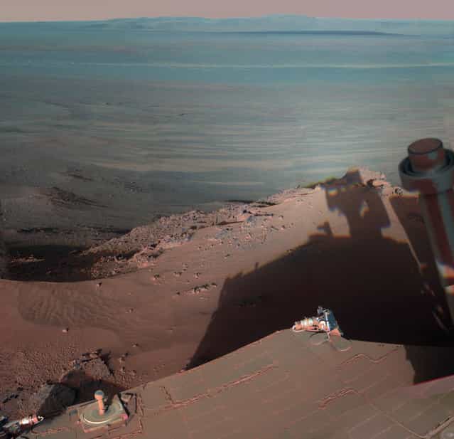 On Mars, NASA's Rover Opportunity catches its own late-afternoon shadow in this dramatically lit view eastward across Endeavour Crater. The rover used the panoramic camera (Pancam) between about 4:30 and 5:00 p.m. local Mars time to record images taken through different filters and combined into this mosaic view. Most of the component images were recorded during the 2,888th Martian day, or sol, of Opportunity's work on Mars (March 9, 2012). At that time, Opportunity was spending low-solar-energy weeks of the Martian winter at the Greeley Haven outcrop on the Cape York segment of Endeavour's western rim. Opportunity has been studying the western rim of Endeavour Crater since arriving there in August 2011. This crater spans 14 miles (22 kilometers) in diameter, or about the same area as the city of Seattle. (Photo by NASA/JPL-Caltech/Cornell/Arizona State Univ.)