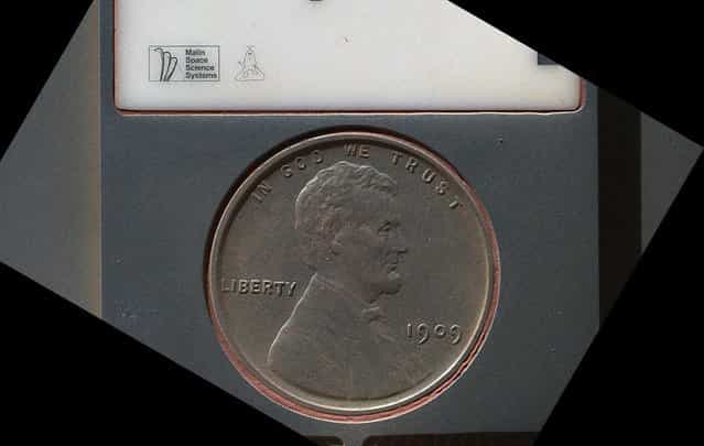 The penny in this image is part of a camera calibration target on NASA's Mars rover Curiosity. The MAHLI camera on the rover took this and other images of the MAHLI calibration target on September 9, 2012. The penny is a nod to geologists' tradition of placing a coin or other object of known scale as a size reference in close-up photographs of rocks, and it gives the public a familiar object for perceiving size easily when it will be viewed by MAHLI on Mars. The specific coin, provided by MAHLI's principal investigator, Ken Edgett, is a 1909 "VDB" penny. That was the first year Lincoln pennies were minted and the centennial of Abraham Lincoln's birth. The VDB refers to the initials of the coin's designer, Victor D. Brenner, which are on the reverse side. The calibration target for the Mars Hand Lens Imager (MAHLI) instrument also includes a [Joe the Martian] character, color references, a metric bar graphic, and a stair-step pattern for depth calibration. (Photo by NASA/JPL-Caltech/Malin Space Science Systems)