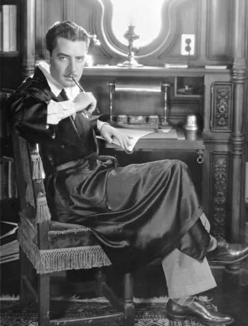 American silent star John Gilbert (1892–1936) sucks thoughtfully on the end of a pen at his writing desk, circa 1930. (Photo by General Photographic Agency)