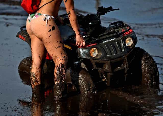 Nicole Devlin of Vero Beach wait.for help to get her ATV out of the mud bog. (Photo by Gary Coronado/The Palm Beach Post)