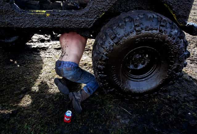 Paul Lambert of Deland repairs a twisted universal joint on his jeep. (Photo by Gary Coronado/The Palm Beach Post)