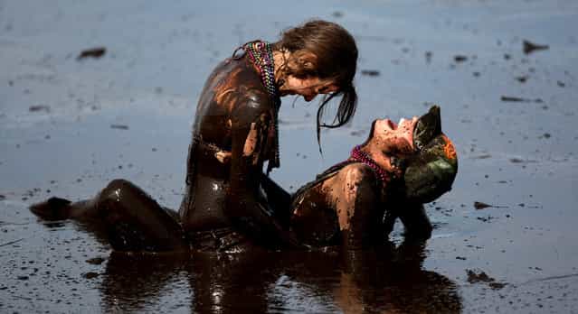 Evans, left, and Welch wrestle in the mud bog. (Photo by Gary Coronado/The Palm Beach Post)