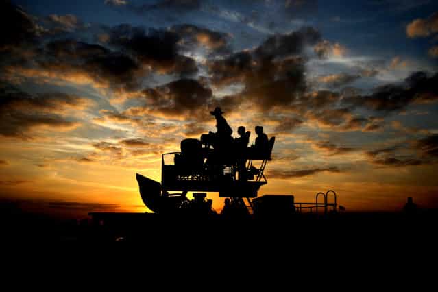 A swamp buggy is silhouetted as the sun sets. (Photo by Gary Coronado/The Palm Beach Post)