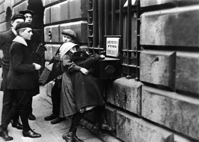 Chidren putting money into a collection box in aid of victims of the [Titanic] disaster, outside Mansion House, London, 1912. (Photo by Hulton Archive)