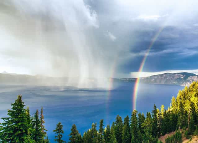 Crater Lake Storm at Sunset: A thunderstorm swirls across the water at Crater Lake National Park, as the setting sun creates a rare double rainbow. Taken from Rim Village, approximately 1,000 feet above the lake's surface, providing a straight-on vantage point of the storm. (Photo by Duke Miller/National Geographic Photo Contest