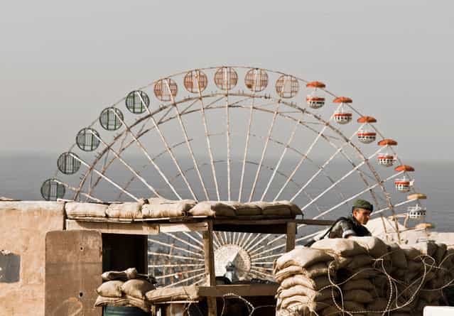 Don't play with war: I was captivated by the scenery before I got my camera out of my bag. In the foreground a soldier in his bunker and in the background a Ferris wheel that looked like it had been shot at. The contrasting dualism in the image struck me before I took the picture. Square/round, adult world/child world, war/peace. Unfortunately I was arrested since I was not allowed to take photos of the military, but I managed to show them a cropped version on my camera screen, displaying only the Ferris wheel. Photo taken in Beirut, Lebanon. (Photo by Janus Langhorn/National Geographic Photo Contest