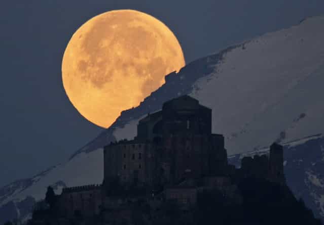 Full Moon setting behind Alps and the Sacra of San Michele: The picture captures the full Moon setting behind the Alps and the Sacra di San Michele, a religious complex situated 1,000 meters up Mount Pirchiriano, some 60 kilometers form Turin, in northern Italy. (Photo by Stefano De Rosa/National Geographic Photo Contest