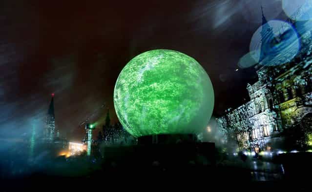 A huge sphere is lit during the Circle of Light Festival launch at Red Square in Moscow, on September 28, 2012. Almost all of central Moscow's famous sites will be used as screens for the festival, including, in addition to the historic buildings in Red Square, the Manege Central Exhibition Hall, the fountain in Manege Square, the Hotel Moskva and even the entrance to Gorky Park. (Photo by Sergey Ponomarev/Associated Press)