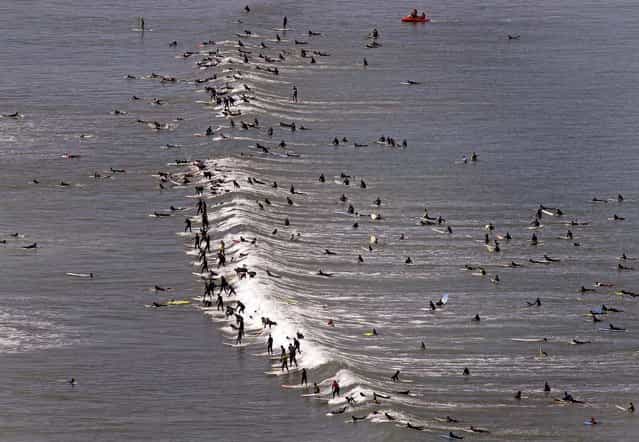 Surfers attempt to break the Guinness World Record for the most surfers on a wave at one time, in Muizenberg on the outskirts of Cape Town, South Africa, on September 30, 2012. (Photo by Schalk van Zuydam/Associated Press)