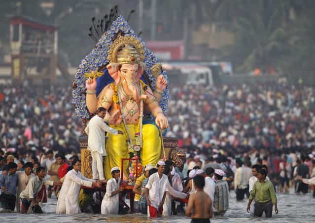 Devotees carry an idol of the Hindu elephant god Ganesh for immersion into the Arabian Sea on the last day of the Ganesh Chaturthi festival in Mumbai, September 29, 2012. Ganesh idols are taken through the streets in a procession accompanied by dancing and singing and later immersed in a river or the sea symbolising a ritual seeing-off of his journey towards his abode, taking away with him the misfortunes of all mankind. (Photo by Noah Seelam/AFP)