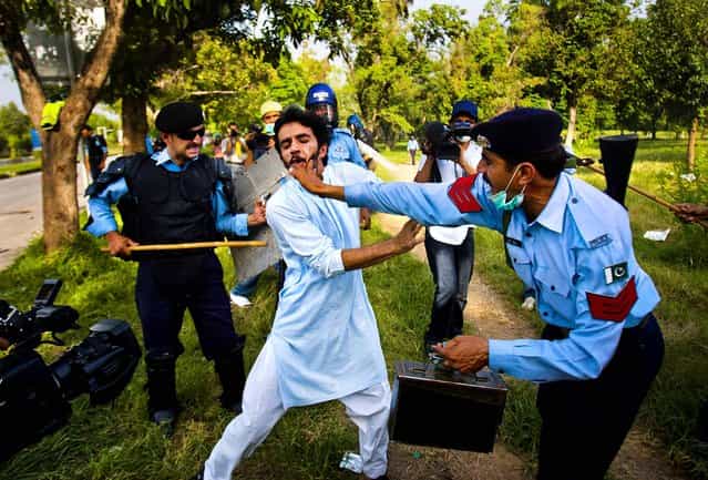Police officers beat a protestor who tried to approach the U.S. embassy, in Islamabad, Pakistan, on September 21, 2012. Demonstrations turned violent and scores of people were killed died after police opened fire on rioters torching a cinema in the northwest city of Peshawar (Photo by Anjum Naveed/Associated Press)