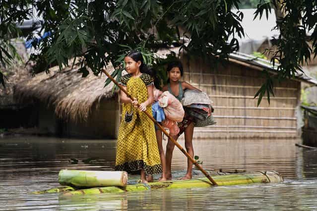 Flood affected children pole a raft in a Burhabrhi village in India, on September 24, 2012. The Assam state government said flood waters there have killed at least seven people and forced nearly a million to leave their homes. (Photo by Anupam Nath/Associated Press)