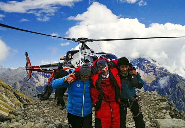A man injured in an avalanche is rescued at the base camp of Mount Manaslu in northern Nepal, on September 23, 2012. The avalanche swept away climbers on a Himalayan peak leaving at least nine dead and six others missing. (Photo by Simrik Air)