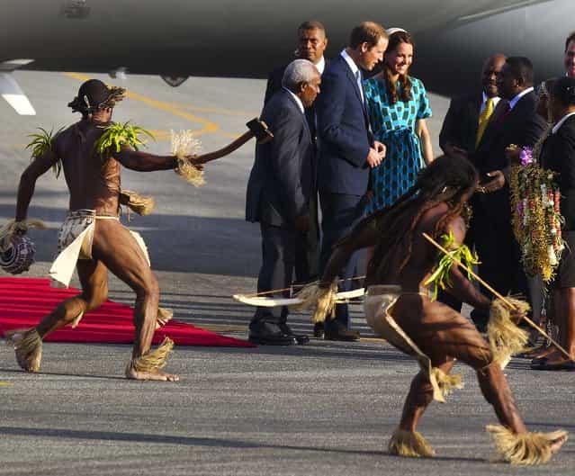Britain's Prince William and wife Kate, the Duke and Duchess of Cambridge, arrive at Honiara International Airport in Solomon Islands, as warriors in traditional dress dance around them, on September 16, 2012. (Photo by Rick Rycroft/Associated Press)