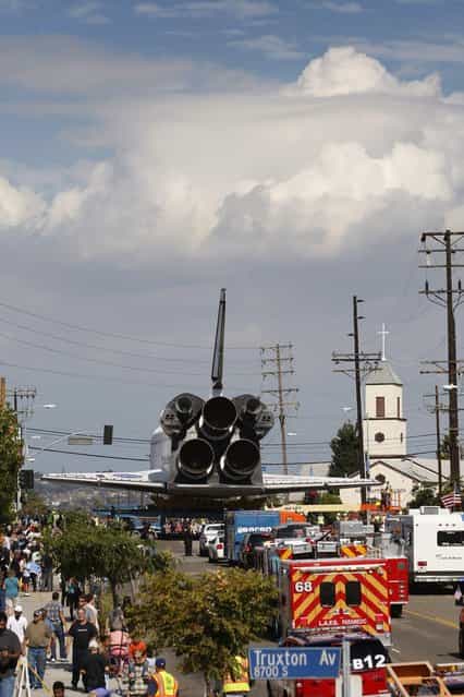 The space shuttle Endeavour approaches the intersection of La Tijera Boulevard and Manchester Avenue as it is transported to the California Science Center in Exposition Park from Los Angeles International Airport (LAX) on October 12, 2012 in Los Angeles, California. Endeavour was flown cross-country atop NASA's Shuttle Carrier Aircraft from Kennedy Space Center in Florida to LAX on its last flight ever on September 21. From there, it was transported to the California Science Center in Exposition Park where it will be on permanent public display. Completed in 1991, Endeavour was built to replace the space shuttle Challenger which disintegrated during a catastrophic re-entry accident. This fifth and final space shuttle orbiter circled the earth 4,671 times and traveled nearly 123 million miles during its 25 missions from 1992 to 2011. (Photo by David McNew)