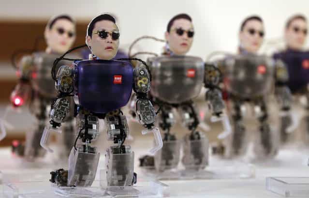 Robots carrying the face of South Korean rapper Psy dance during a ceremony to promote South Korea's robot industry in Seoul on October 17, 2012. The 34-year-old Psy has rocketed to international fame with his song [Gangnam Style] and its much-imitated dance moves which has gone viral on YouTube. (Photo by Yonhap, Park Dong-joo/AP Photo)