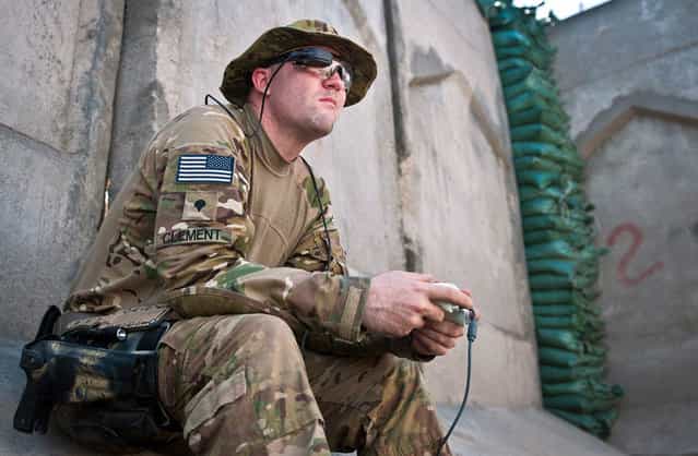 U.S. Army Spc. Andrew B. Clement, an explosive ordnance disposal technician assigned to 129th EOD, attached to 3rd Brigade Combat Team, 25th Infantry Division, Task Force Bronco, uses an Xbox controller and a computer viewfinder to maneuver an EOD robot at Combat Outpost Honaker-Miracle in eastern Afghanistan's Kunar province, on August 1, 2012. (Photo by Sgt. 1st Class Mark Burrell/U.S. Army)