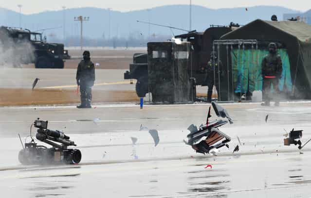 An armed robot controlled by South Korean commandos destroys a mockup of a bomb during an anti-terror drill at Incheon International Airport, west of Seoul, on February 29, 2012. (Photo by Kim Jae-Hwan/AFP Photo)