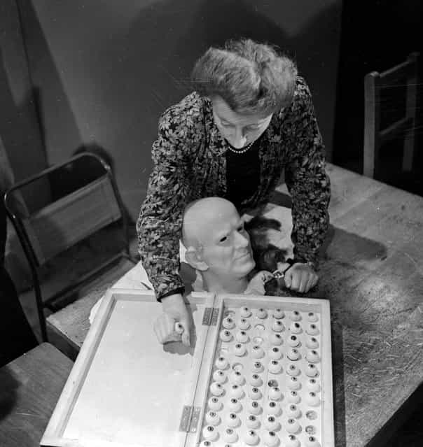 Vera Bland chooses the right colour eyeballs for a wax head of Cardinal Bernard Griffin, Archbishop of Westminster in the workshop of Madame Tussaud's, London, June 1946. (Photo by George Konig/Keystone Features)