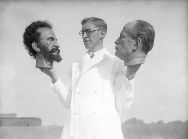 Bernard Tussaud, grandson of Swiss modeller Madame Tussaud, holds two wax heads, one of Haile Selassie, Emperor of Abyssinia (Ethiopia) and the other of Italian dictator Benito Mussolini. September 1935. (Photo by Fox Photos)