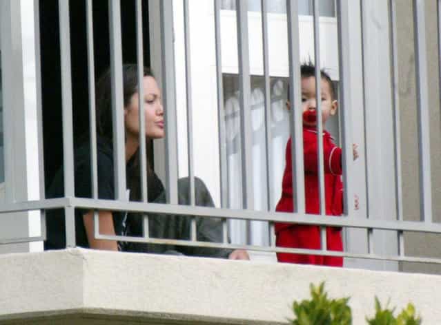 Actress Angelina Jolie plays with her son, Maddox, on the balcony of a hotel on December 30, 2002 in Beverly Hills, California. (Photo by Frazer Harrison)