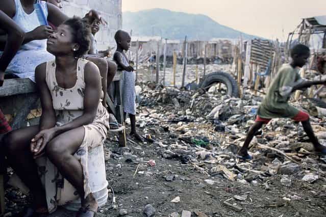 Cap-Haitien, Haiti. In Bas-Aviation slums, located at the end of the airport runways, a woman is having her hair done in October 2003. (Photo by Jean-Claude Coutausse)
