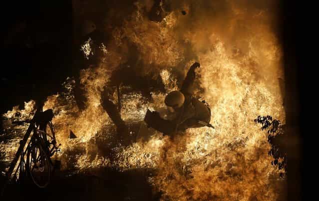 A police officer is engulfed by flames from a petrol bomb thrown by protesters in front of the parliament during clashes in Athens, November 7, 2012. Lawmakers in Greece backed a new round of austerity measures, despite violent protests across the country. (Photo by Dimitri Messinis/Associated Press)