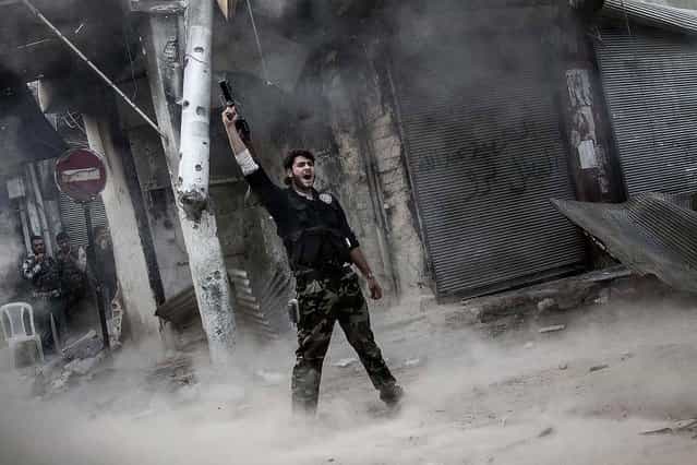 A rebel fighter claims victory after he fires a shoulder-fired missile toward a building where Syrian troops loyal to President Bashar Assad are hiding while they attempt to gain terrain against the rebels, during heavy clashes in the Jedida district of Aleppo, November 4, 2012. (Photo by Narciso Contreras/Associated Press)