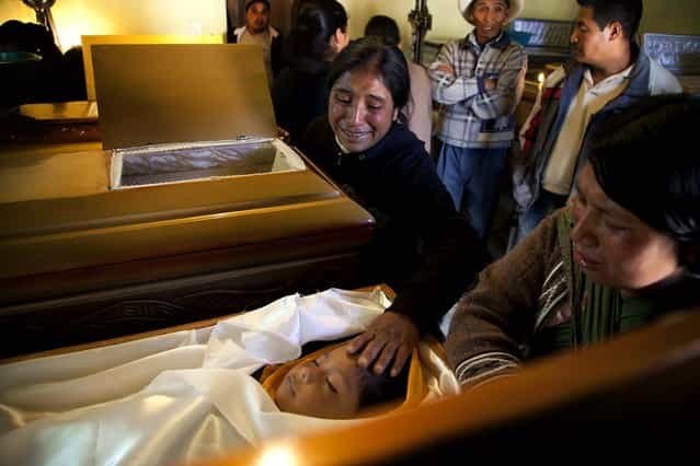 Nadalinis Juarez touches the forehead of her young nephew Dilbert Vazquez during a funeral service in San Cristobal Cucho, Guatemala, November 8, 2012. The 4-year-old died when a magnitude 7.4 earthquake struck on Wednesday, collapsing his home, burying him and 9 members of his family in the rubble. The powerful earthquake killed at least 48 people and left dozens more missing. (Photo by Moises Castillo/Associated Press)