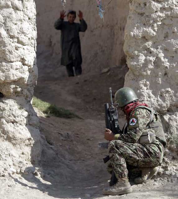 An Afghan soldier of 215th Maiwand Corps takes up position in an alley during a joint patrol with U.S. marines of Fox Co, 2nd Battalion, 7th Marines Regiment in a village at Musa Qal-Ah district in Helmand province, southwestern Afghanistan on November 1, 2012. (Photo by Erik De Castro/Reuters Photo)