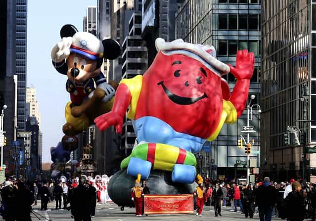 The Kool-Aid Man balloon and the Mickey Mouse balloon participate in the 86th annual Macy's Thanksgiving Day Parade in New York. (Photo by Librado Romero/The New York Times)
