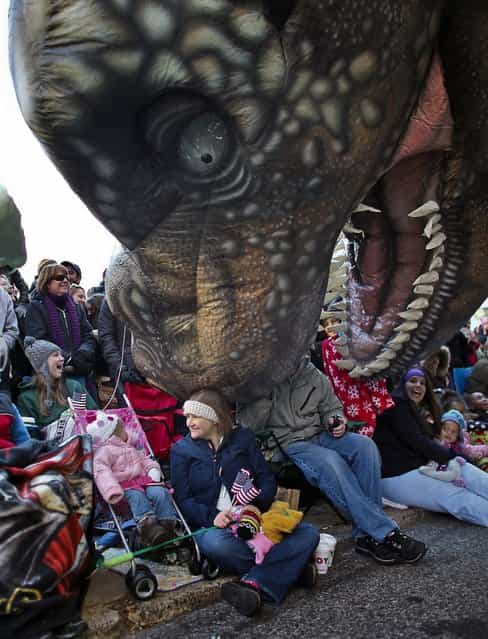 Handlers lower the T-Rex balloon down to the spectators during the 93rd annual Thanksgiving Day parade in Philadelphia. (Photo by Joseph Kaczmarek/Associated Press)