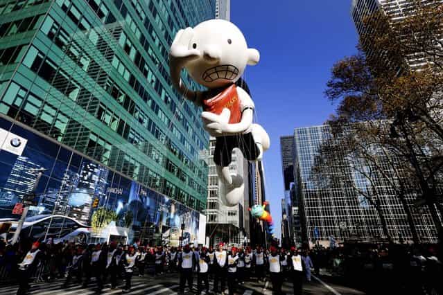 The Diary of A Wimpy Kid balloon and its wranglers travel down the Avenue of the Americas during the 86th annual Macy's Thanksgiving Day Parade. (Photo by Librado Romero/The New York Times)