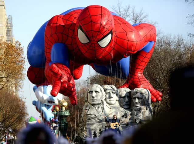 The Spiderman balloon floats over Don McLean during the 86th annual Macy's Thanksgiving Day Parade in New York. (Photo by Suzanne DeChillo/The New York Times)