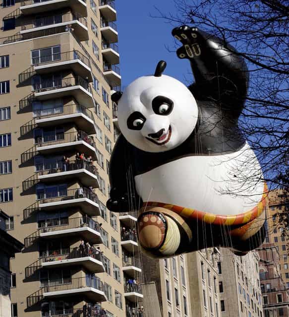 The Kung Fu Panda balloon passes an apartment building on New York's Central Park West during the 86th annual Macy's Thanksgiving Day Parade. (Photo by Louis Lanzano/Associated Press)