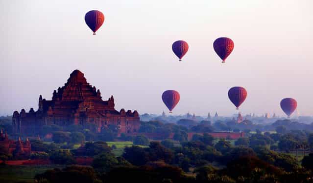 Balloons fly across some of Myanmar's 3,000 Buddhist temples during a sunrise flight in Bagan, November 13, 2012. (Photo by Mark Baker/Associated Press)