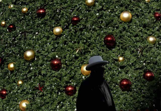 A man walks past the large Macy's Tree at Union Square in San Francisco, November 23, 2012. (Photo by Jeff Chiu/Associated Press)