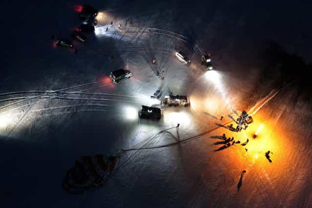 A Russian Soyuz TMA-05M spacecraft, right, lays on the ground as members of a rescue team stand nearby after it landed in a remote area near the town of Arkalyk, Kazakhstan, November 19, 2012. Three astronauts touched down in the dark, chilly expanses of central Kazakhstan onboard the Soyuz capsule after a 125-day stay at the International Space Station. (Photo by Maxim Shipenkov/Pool)