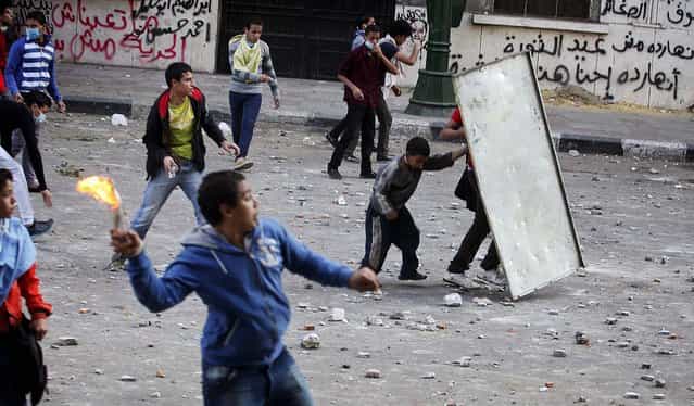 Protesters throw rocks and Molotov cocktails at police in downtown Cairo, November 25, 2012. On Sunday, the Egyptian justice minister joined criticism of a sweeping edict issued Thursday by President Mohamed Morsi that exempted the president's decrees from judicial review until ratification of a constitution. (Photo by Tara Todras-Whitehill/The New York Times)