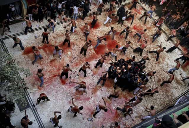 Blood is splatered on the floor of a mosque as Shiite Muslims flagellate themselves during a Muharram procession in New Delhi, November 25, 2012. (Photo by Kevin Frayer/Associated Press)