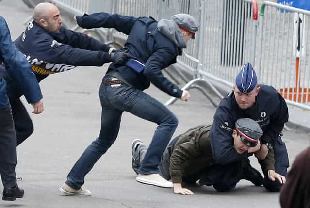 Belgian police officers arrest Flemish separatists after they shout anti-monarchy slogans outside a Te Deum mass to celebrate King's Day at the Saint-Gudule cathedral in Brussels November 15, 2012. (Photo by Francois Lenoir/Reuters)