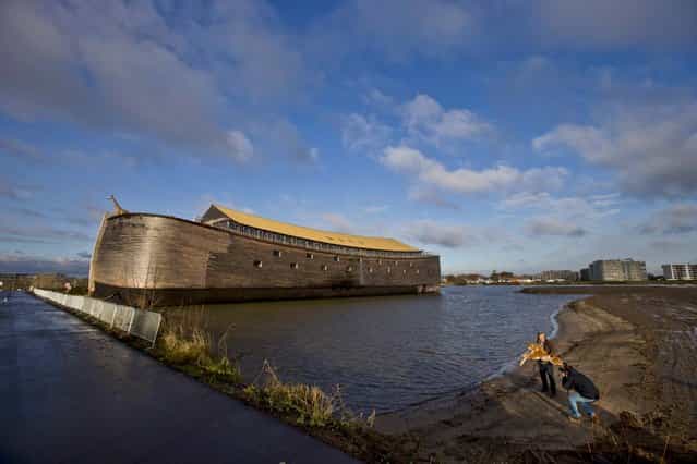 Johan Huibers holds a toy tiger for a photographer in front of the full scale replica of Noah's Ark in Dordrecht, Netherlands, December 10, 2012. Three thousand people a day can visit the replica. (Photo by Peter Dejong/Associated Press)