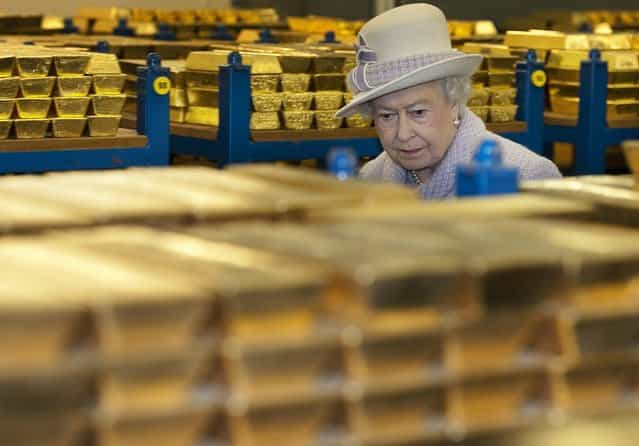 Queen Elizabeth II inspects gold reserves in a vault at the Bank of England in London, December 13, 2012. (Photo by Eddie Mulholland)