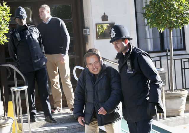 A man wearing a Prince William, Duke of Cambridge mask is escorted away by a police officer from the King Edward VII Private Hospital on December 4, 2012 in London, England. Catherine, Duchess of Cambridge spent her first night in the hospital after yesterday's announement of her pregnancy and the fact she was suffering from hyperemesis gravidarum or acute morning sickness. (Photo by Chris Jackson)