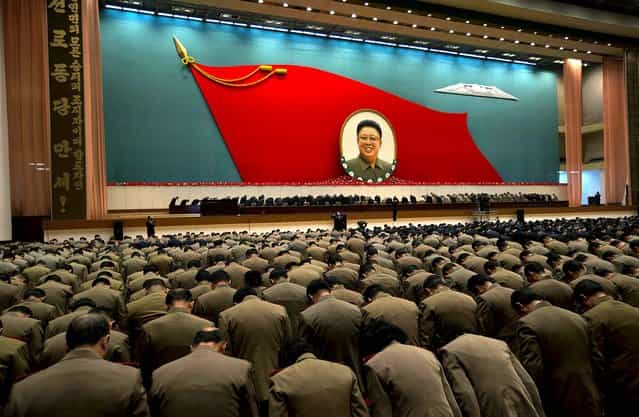 North Korean military officers bow at an image of the late North Korean leader Kim Jong Il during a national meeting of top party and military officials, on the eve of the first anniversary of Kim's death, in Pyongyang, December 16, 2012. (Photo by Ng Han Guan/Associated Press)